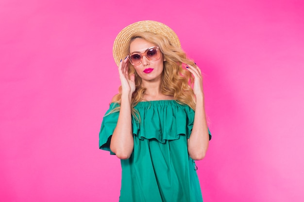 Fashion studio portrait of glamour girl, stylish clothes sunglasses on pink background with