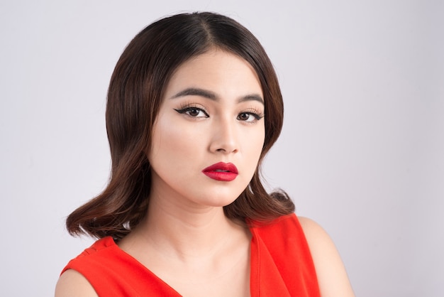 Fashion studio portrait of gorgeous sensual asian woman with dark hair wears elegant red dress