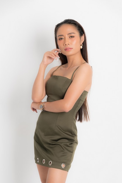 Fashion style catalog casual clothing for party sexy beautiful woman black long hair natural make up wear green dress costume perfect body shape suit at studio shoot on white background and shadow.