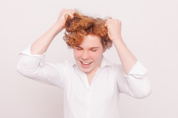 Fashion, style, people concept - Portrait of young tender redhead teenage man with healthy freckled skin wearing white top looking at camera with serious or pensive expression.