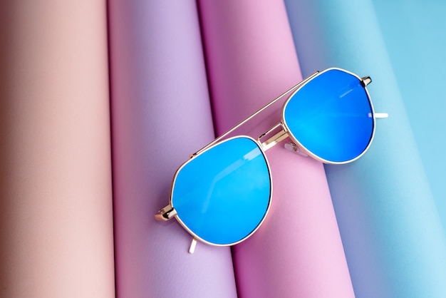 Fashion of Sunglasses with blue lens put on colorful paper background