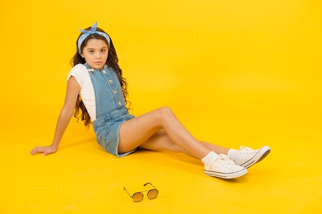 Fashion trend Little fashionista Cute small kid fashion girl Fashion accessories Summer outfit concept Girl long curly hair sit relaxing Carefree happy childhood Modern clothing for teen