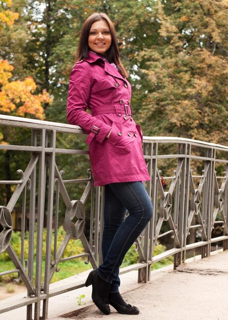 Fashion woman on bridge in autumn park