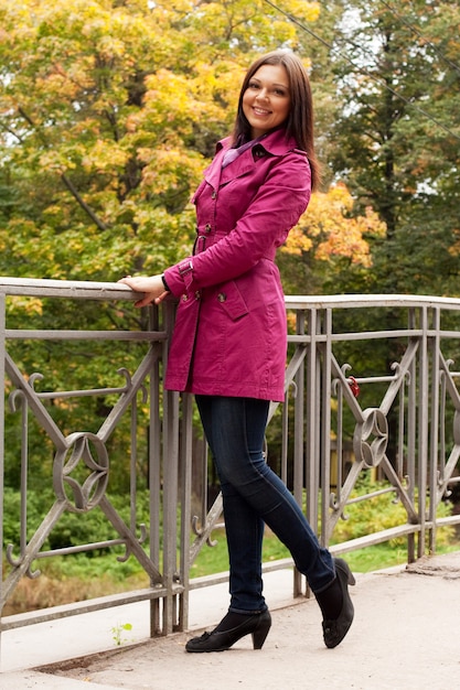 Fashion woman on bridge in autumn park