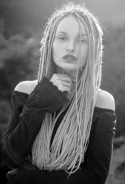 Fashion woman outdoor sunny portrait woman with long dreadlocks haircare concept