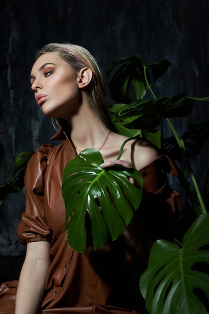 Fashion woman with tropical leaves and neon light