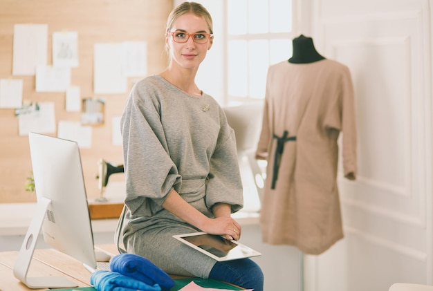 Photo fashion young designer woman measuring a dress