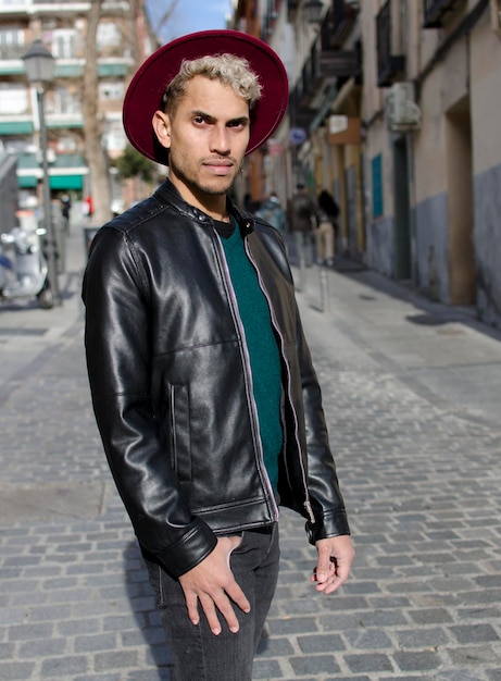 Fashion young model with leather jacket and red hat in the street