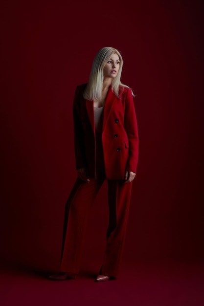 Fashion young woman in red suit Red background