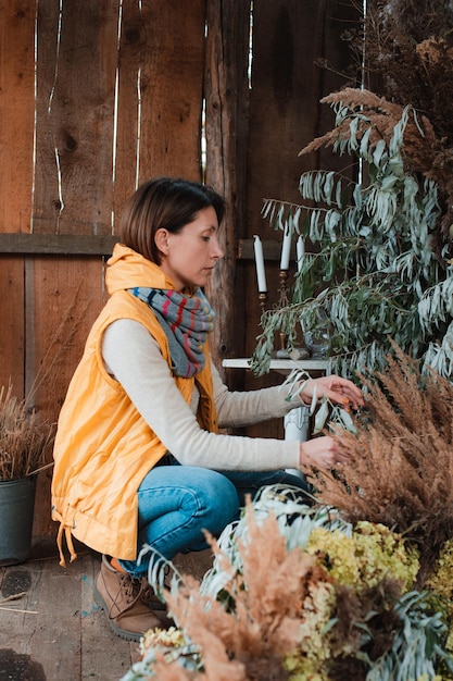 Fashionable florist decorates the composition with dried flowers