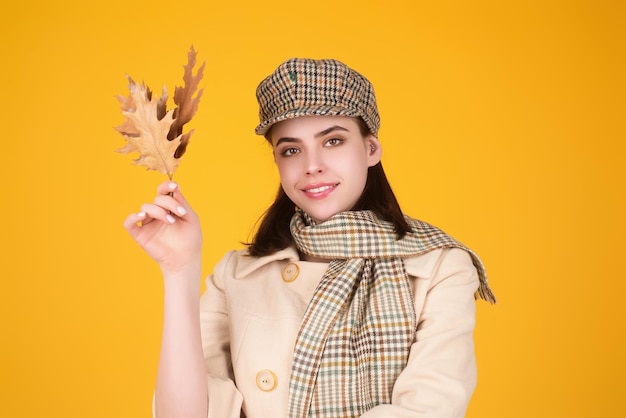 Fashionable hipster woman in trendy autumn fall outfit stylish hat beautiful girl hold autumn maple