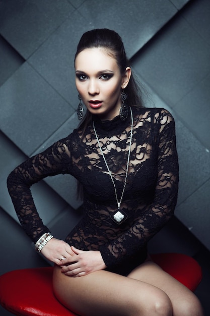 Fashionable model sitting in a red chair