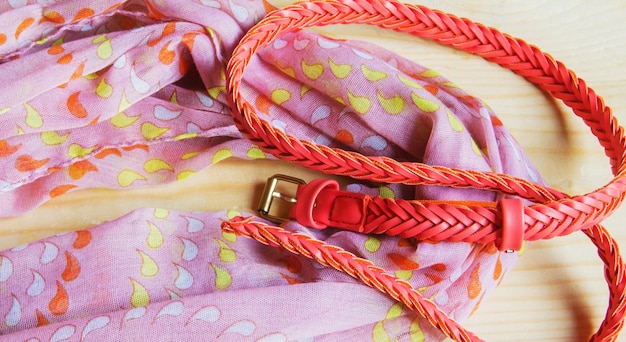 Fashionable pink accessories on wooden background scarf belt