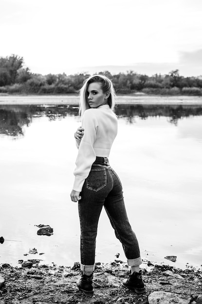 Fashionable portrait of a beautiful young woman outdoors Black and white vertical photo