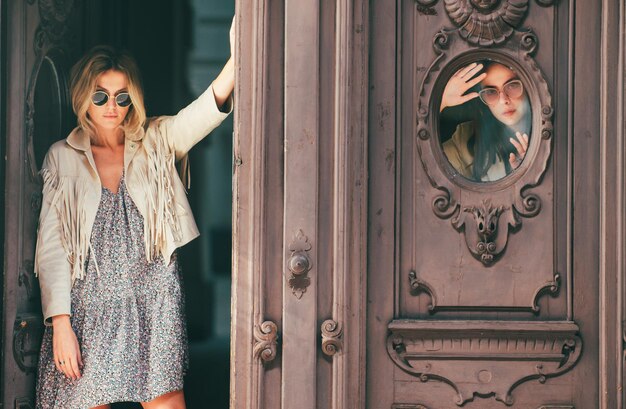 Photo fashionable woman face near vintage gate on the street fashion street style