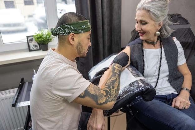 Photo fashionable woman. trendy mature woman in the tattoo salon