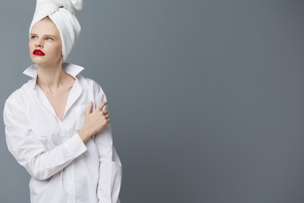 Fashionable woman with a towel on his head in a white shirt isolated background