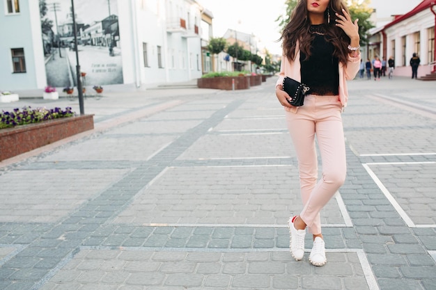 Fashionable womens look with pink suite and black top.