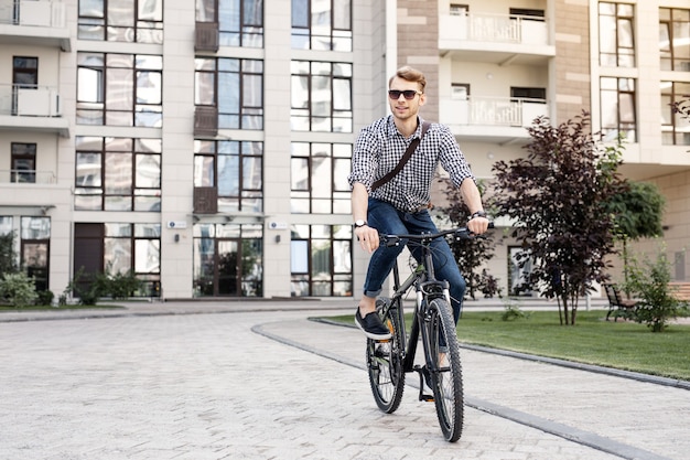 Fast bike. Positive happy man smiling while enjoying his ride on the bicycle