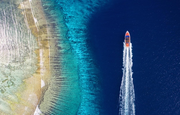 Fast boat on the sea Aerial view of luxury floating boat on blue water at sunny day Seascape with motorboat in bay Travel and vacation image