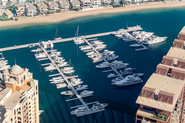 Fast boats and luxury yachts are parked in the port at the pier near beach View from above