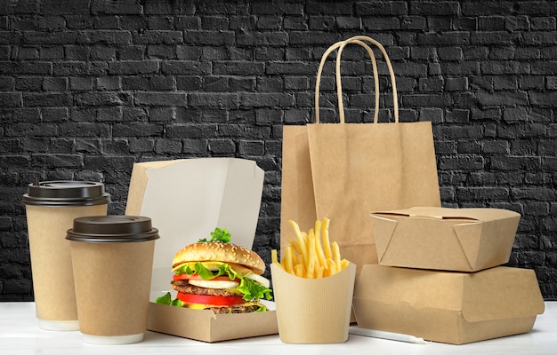 Fast food big lunch packaging set on black brick wall background