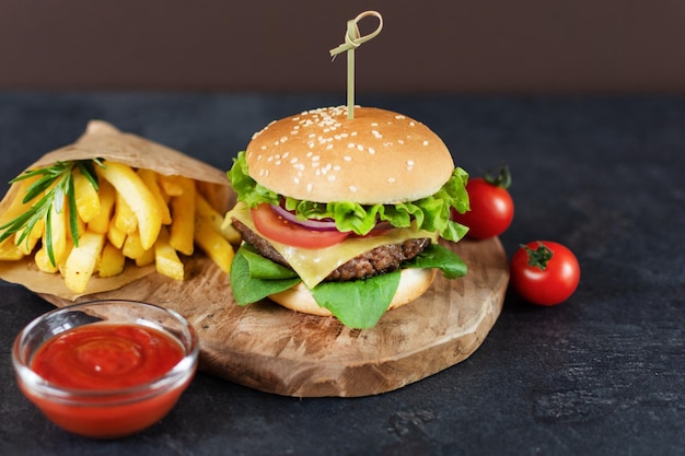 Fast food burger menu french fries and ketchup sauce on dark background