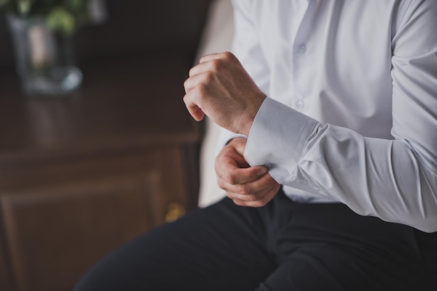 Fastening the cufflinks on the sleeve of his shirt 2411