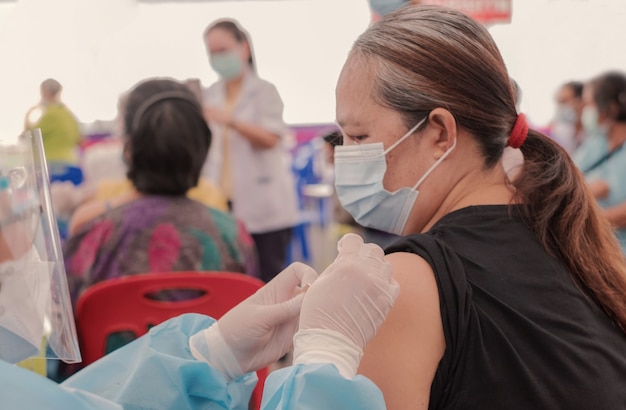 Fat Asia senior woman has gone to vaccinate coronavirus covid with medical staff in a field hospitel