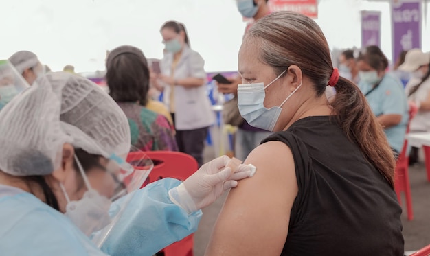 Fat Asia senior woman has gone to vaccinate coronavirus covid19 with medical staff in a field hospitel. a place set up by the government.