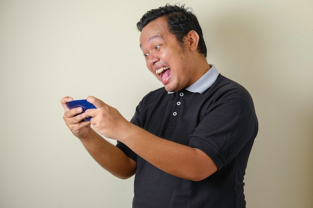 Fat Asian male looks confident while accessing his smart phone, the man shows a surprised expression