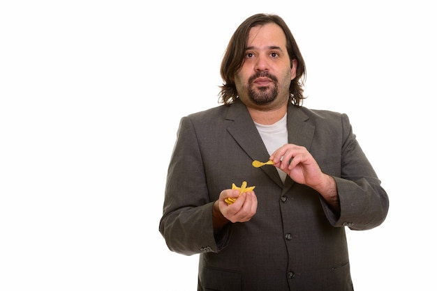 Fat Caucasian businessman eating mouthful of chips isolated on white