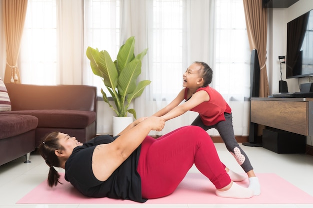 Fat woman asian with little girl exercising at home, Sport and recreation idea concept.