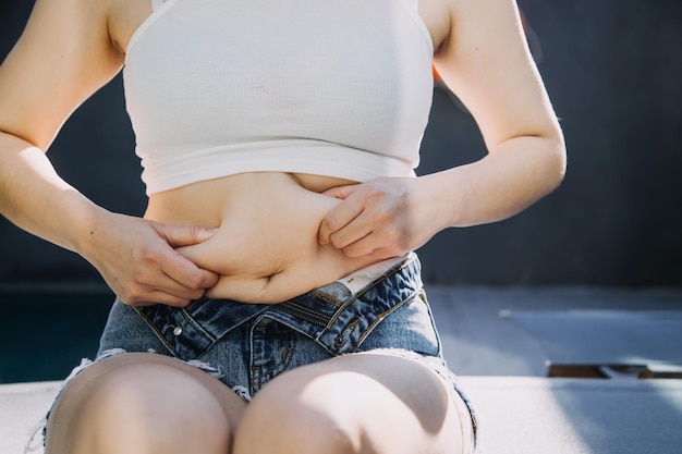 Fat woman fat belly chubby obese woman hand holding excessive belly fat with measure tape woman diet lifestyle concept