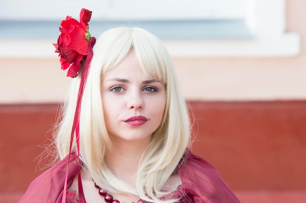 Fatal blonde with a red flower in her hair