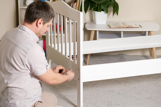 The father assembles the children's bed for the child