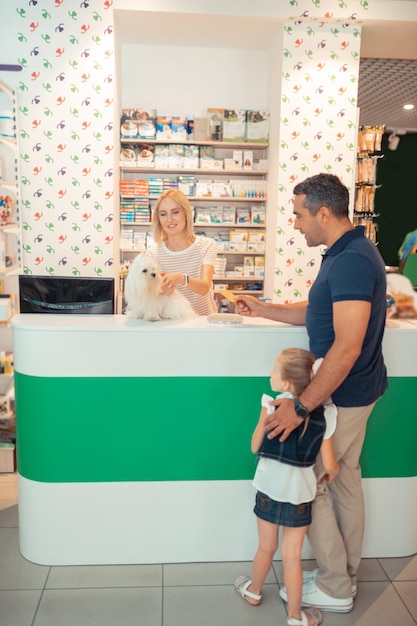 Father buying white fluffy dog for his cute lovely daughter