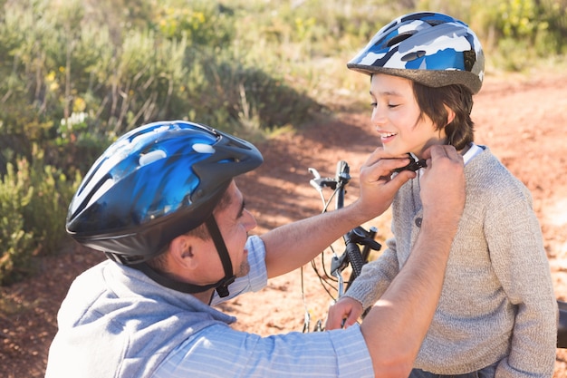 Father clipping on sons helmet 