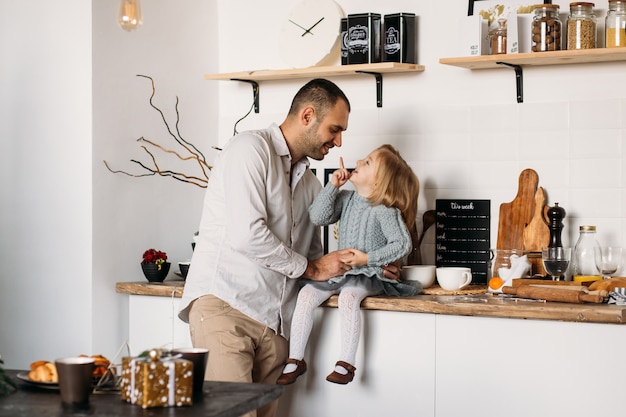 Father and daughter are having fun in kitchen at home