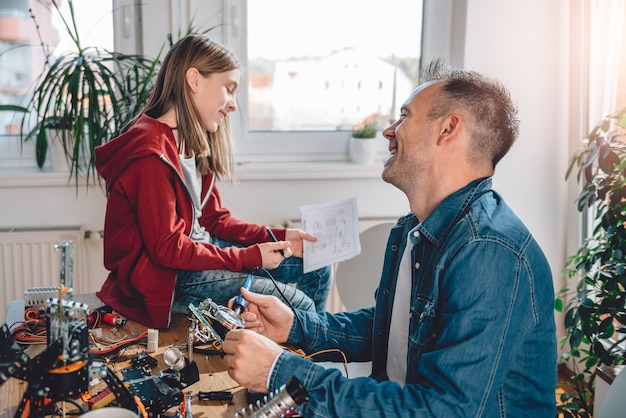 Father and daughter building robot and having fun