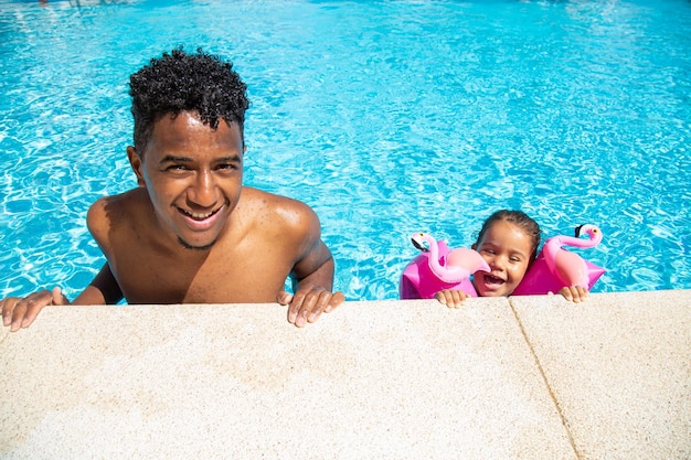 Father and daughter having fun in pool