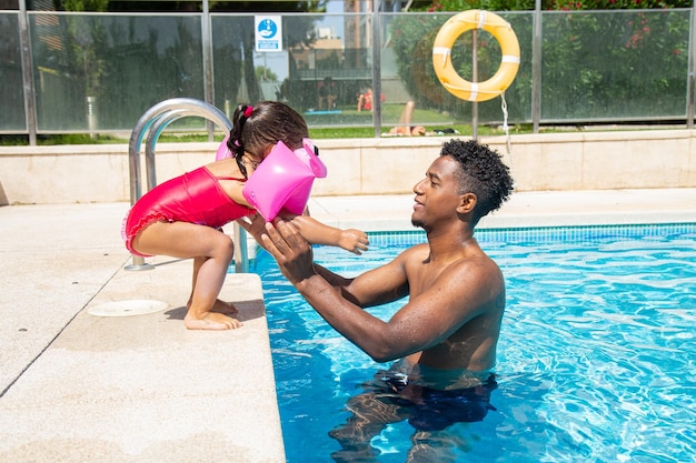 Father and daughter having fun in pool