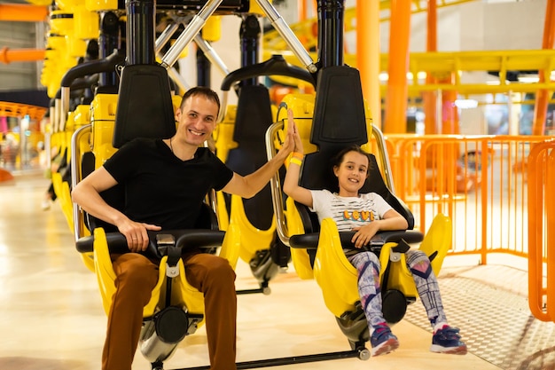 Father and daughter having fun on rollercoaster.