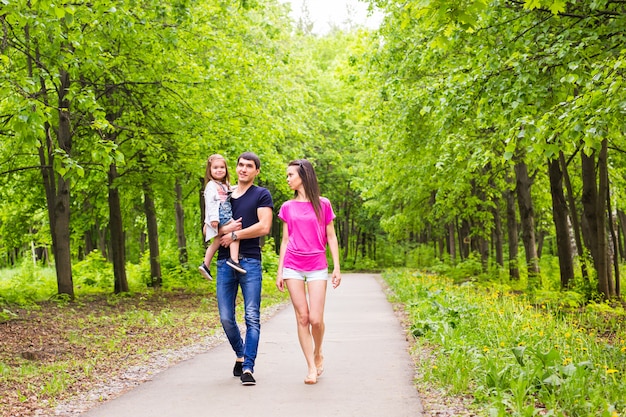 Father, daughter and mother walking outdoors. Happy family.