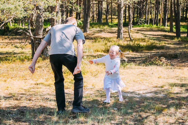 Father and daughter playing in a spring forest Active people are having a good time outdoors