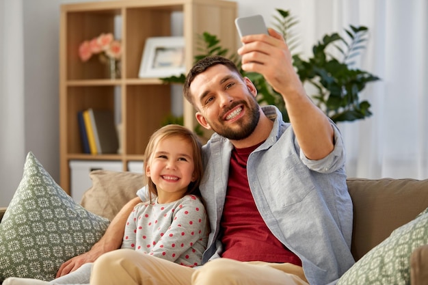 father and daughter taking selfie at home