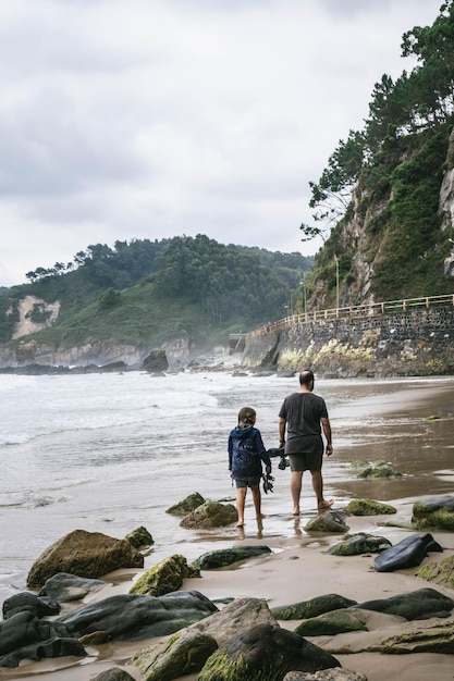 Father and daughter walking on the beach Vertical phot