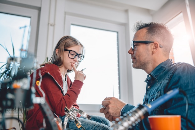 Father and daughter working together in workshop