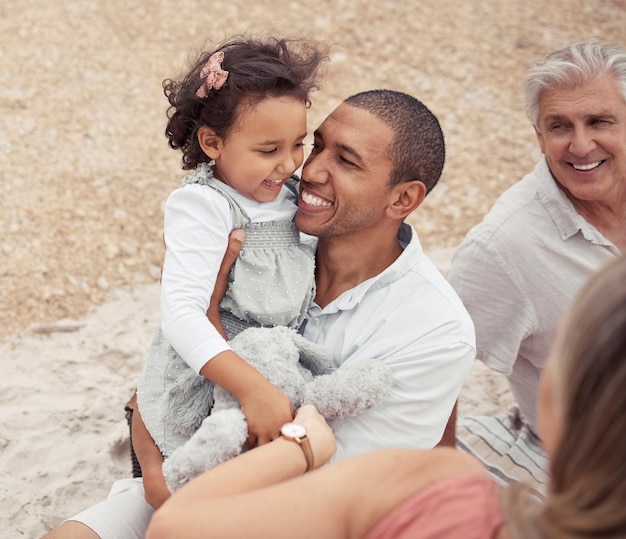 Father family and beach this summer happy to be with his child People on a picnic on vacation smiling and baby is happy Mother grandfather dad and young girl on this sunny day