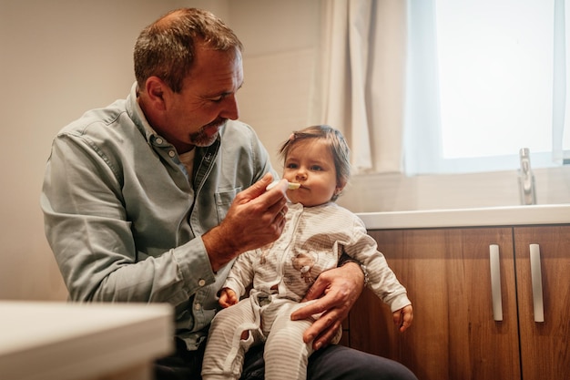 Father feeding a baby girl